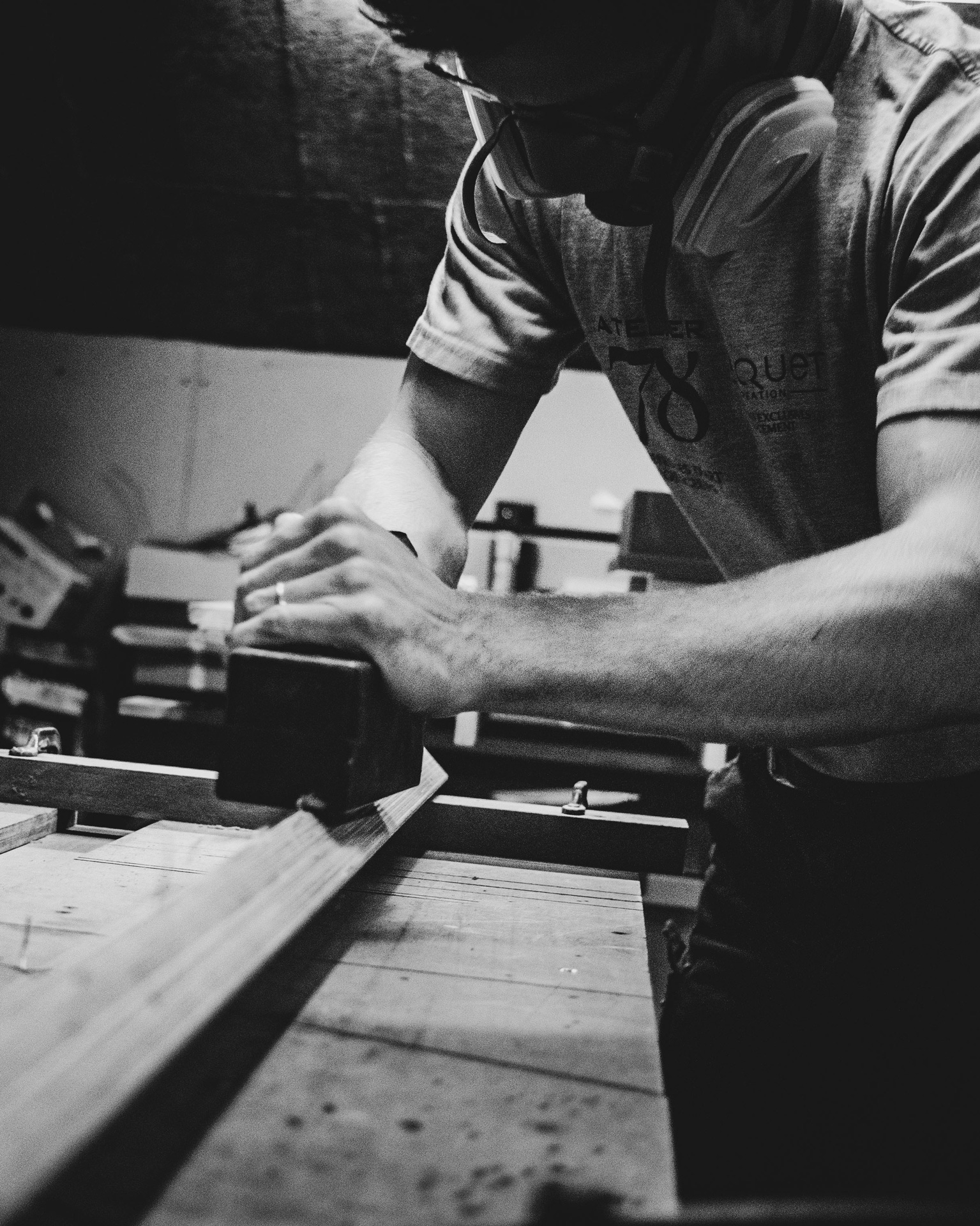 OSPIN Design and Build - Black and white image of a craftsman in a woodworking workshop