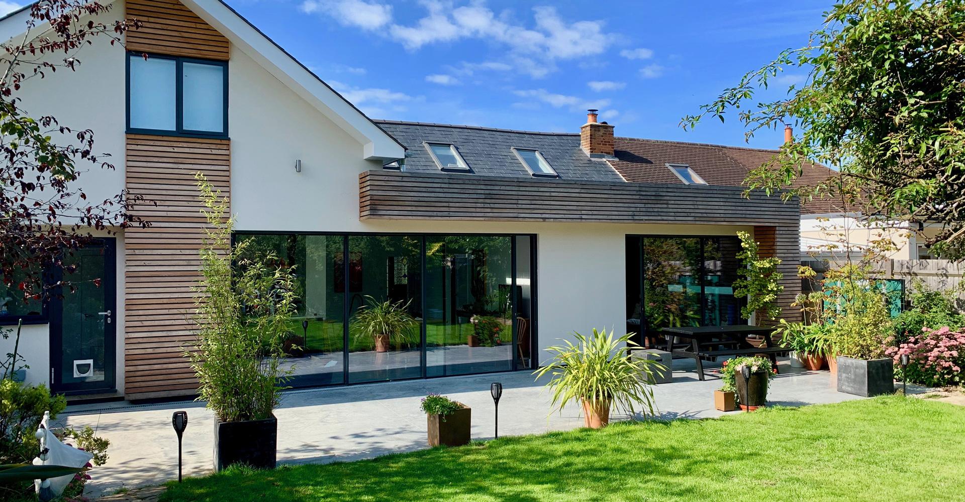 The project extends and remodels the house to create a brighter, more spacious home while making better use of the existing footprint.