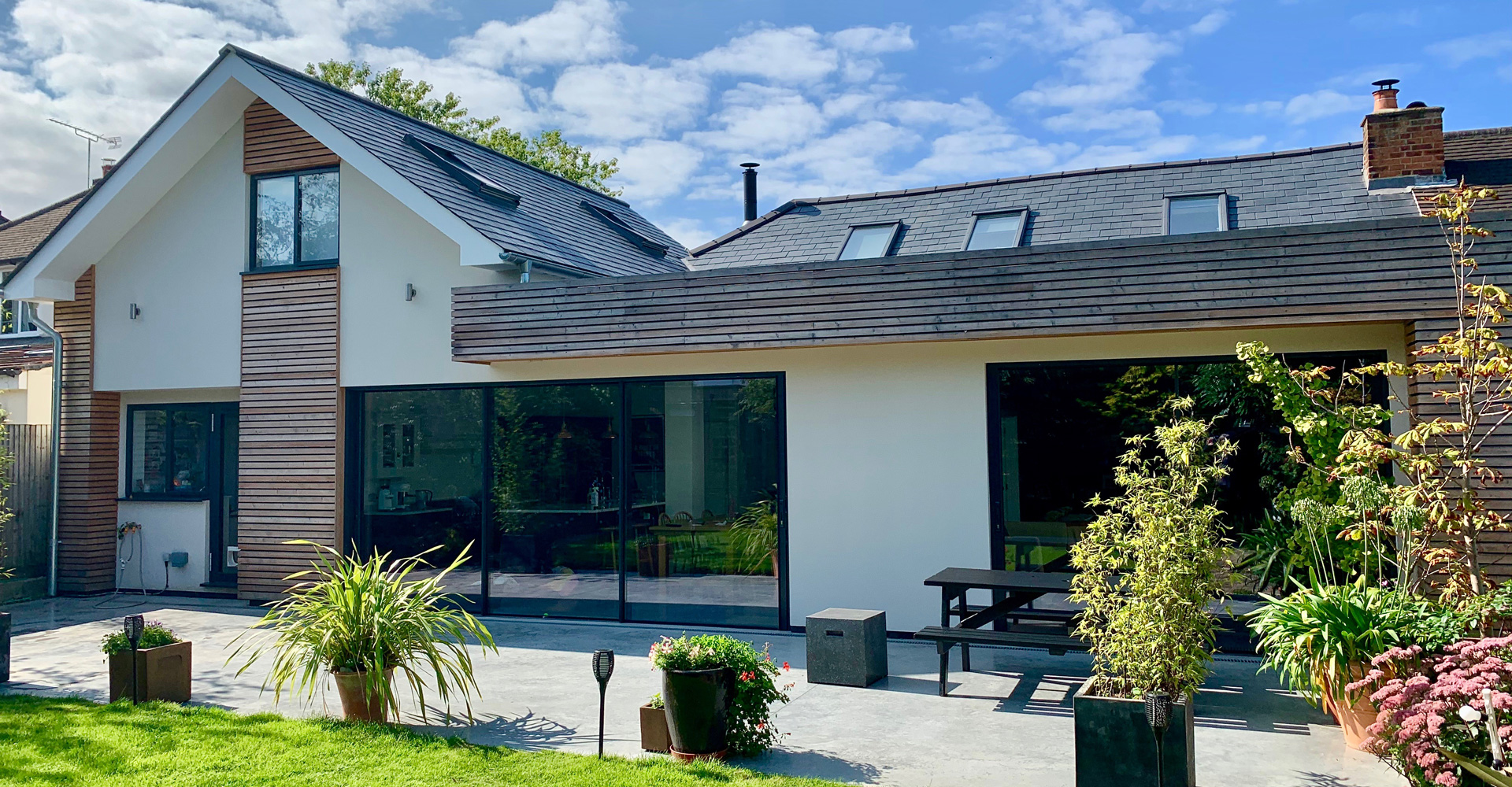 Externally, white render, timber cladding and aluminium glazing give the house a lighter and more contemporary presence. The redesign brings clarity and openness to the home, creating a more practical layout suited to modern family living.