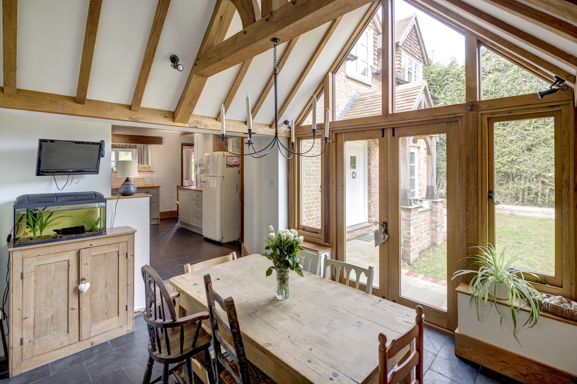 The use of exposed oak framing, large glazed panels and vaulted ceilings introduces a sense of openness without losing the intimacy of the original cottage.