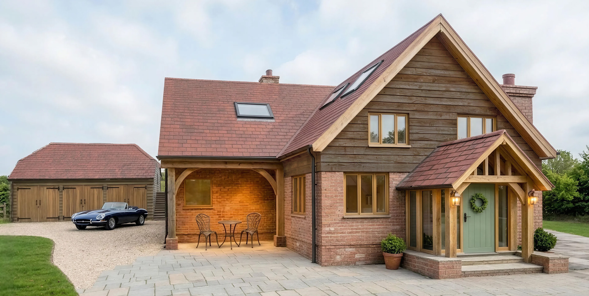A new three-bay garage sits alongside the house, completing the arrangement and providing practical storage and parking.