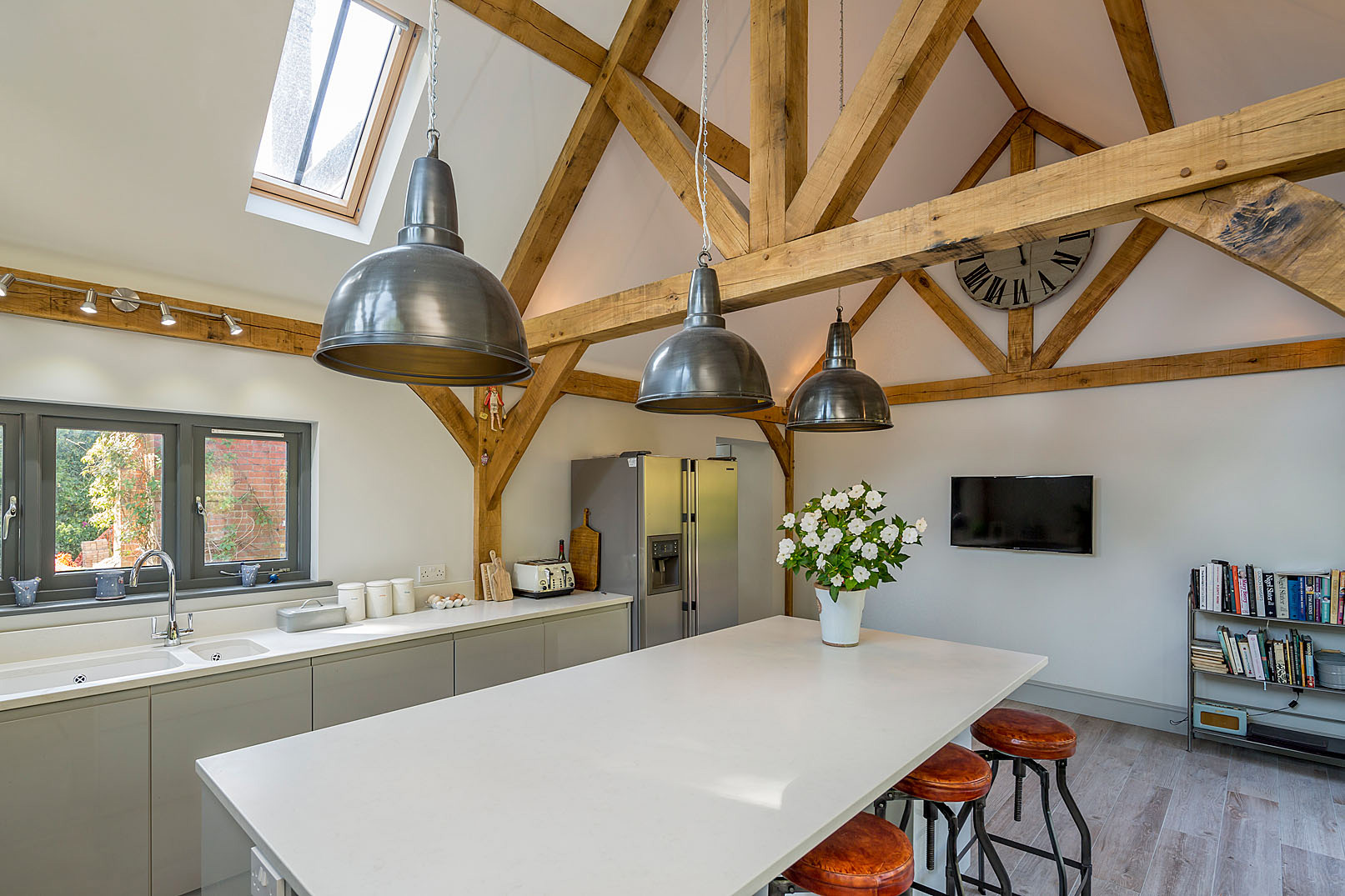 The design introduces a carefully considered oak-framed kitchen extension positioned to make the most of the surrounding gardens.