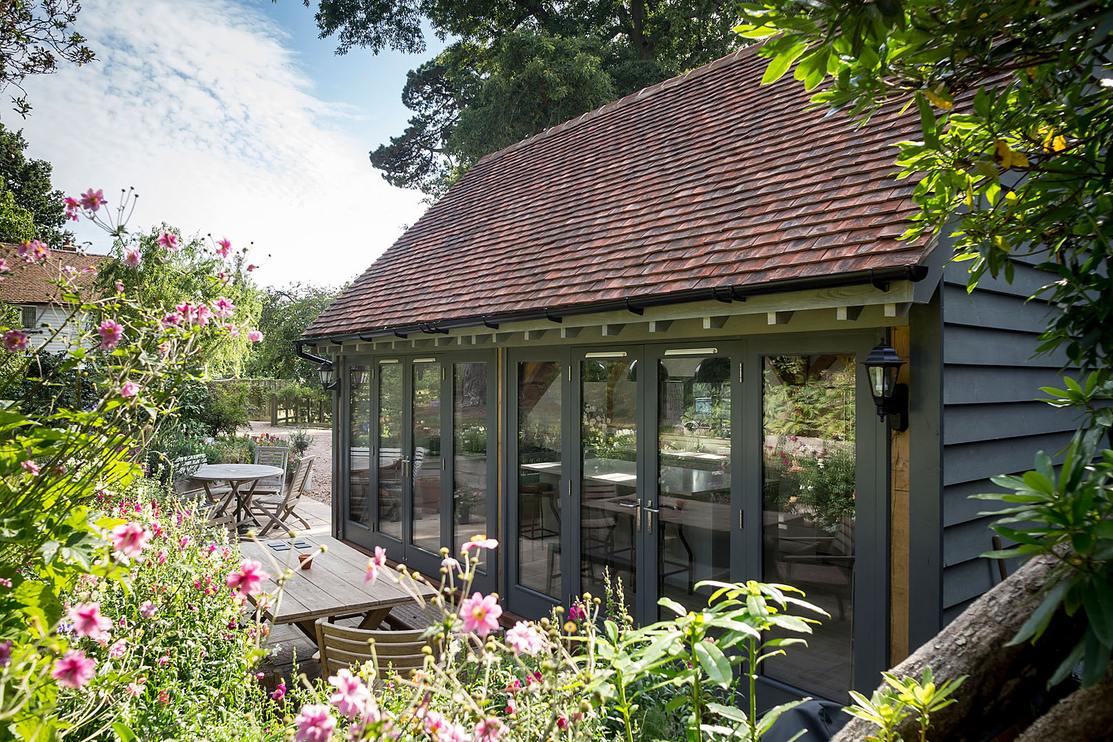 The extension also forms a sheltered courtyard, offering a private spot for outdoor dining and strengthening the relationship between the house and its landscape.