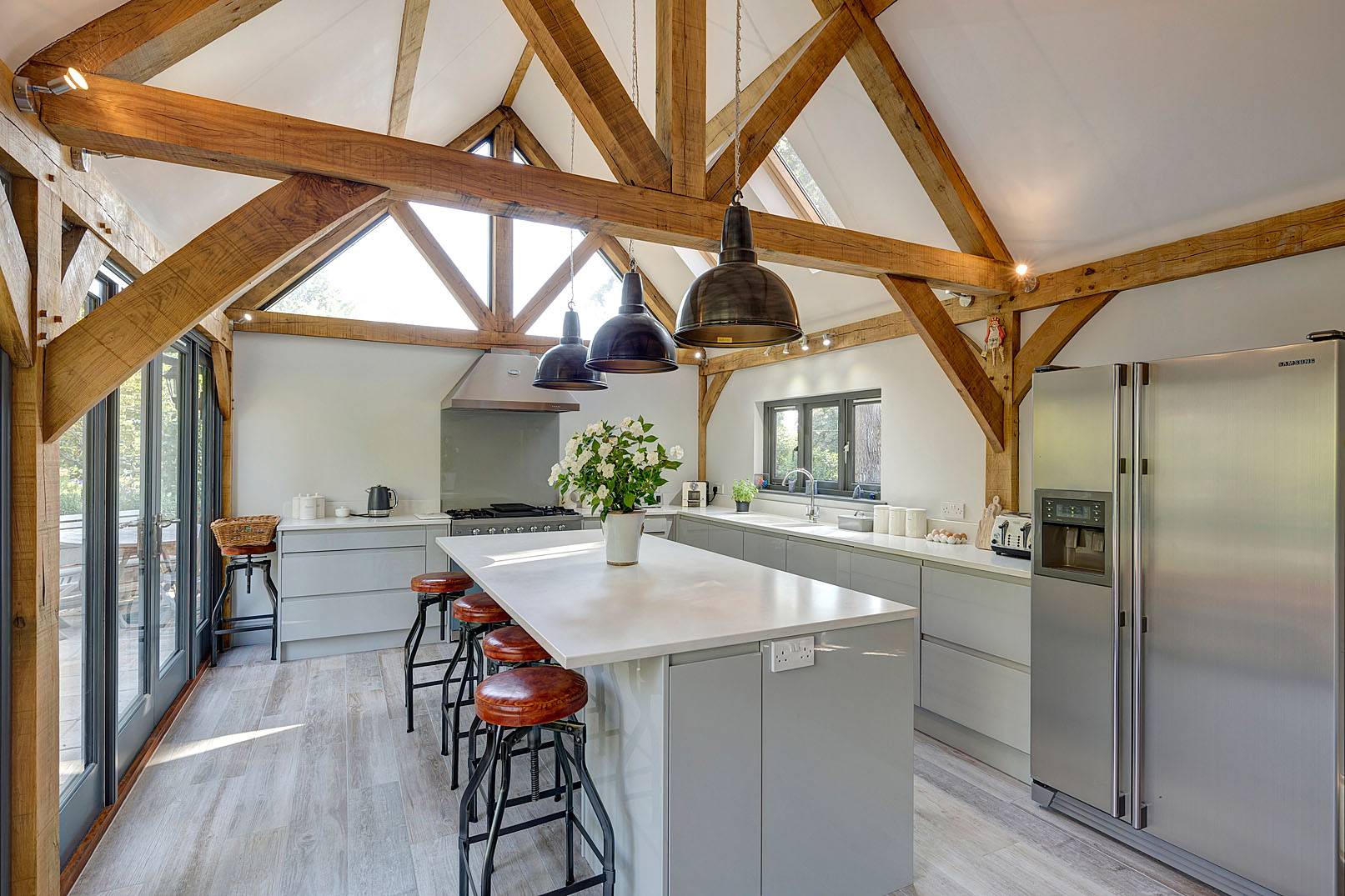 The design introduces a carefully considered oak-framed kitchen extension positioned to make the most of the surrounding gardens.