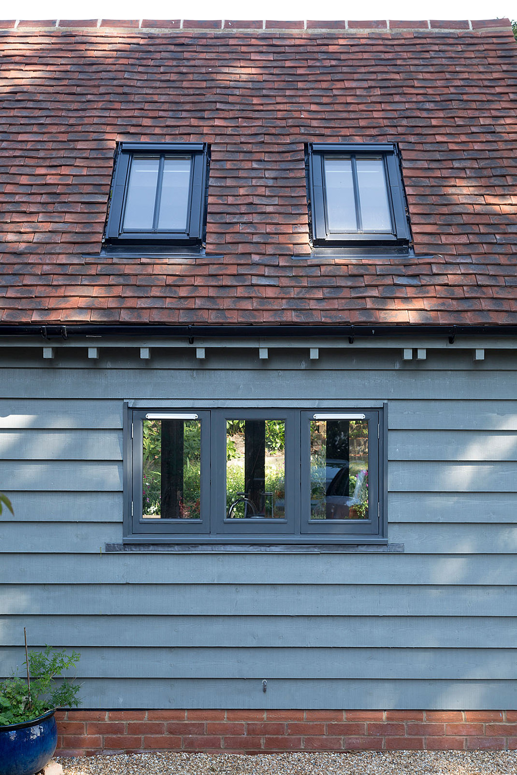 The new addition sits comfortably alongside the existing building, complementing its brickwork and tiled roof while quietly restoring balance to the home’s layout.
