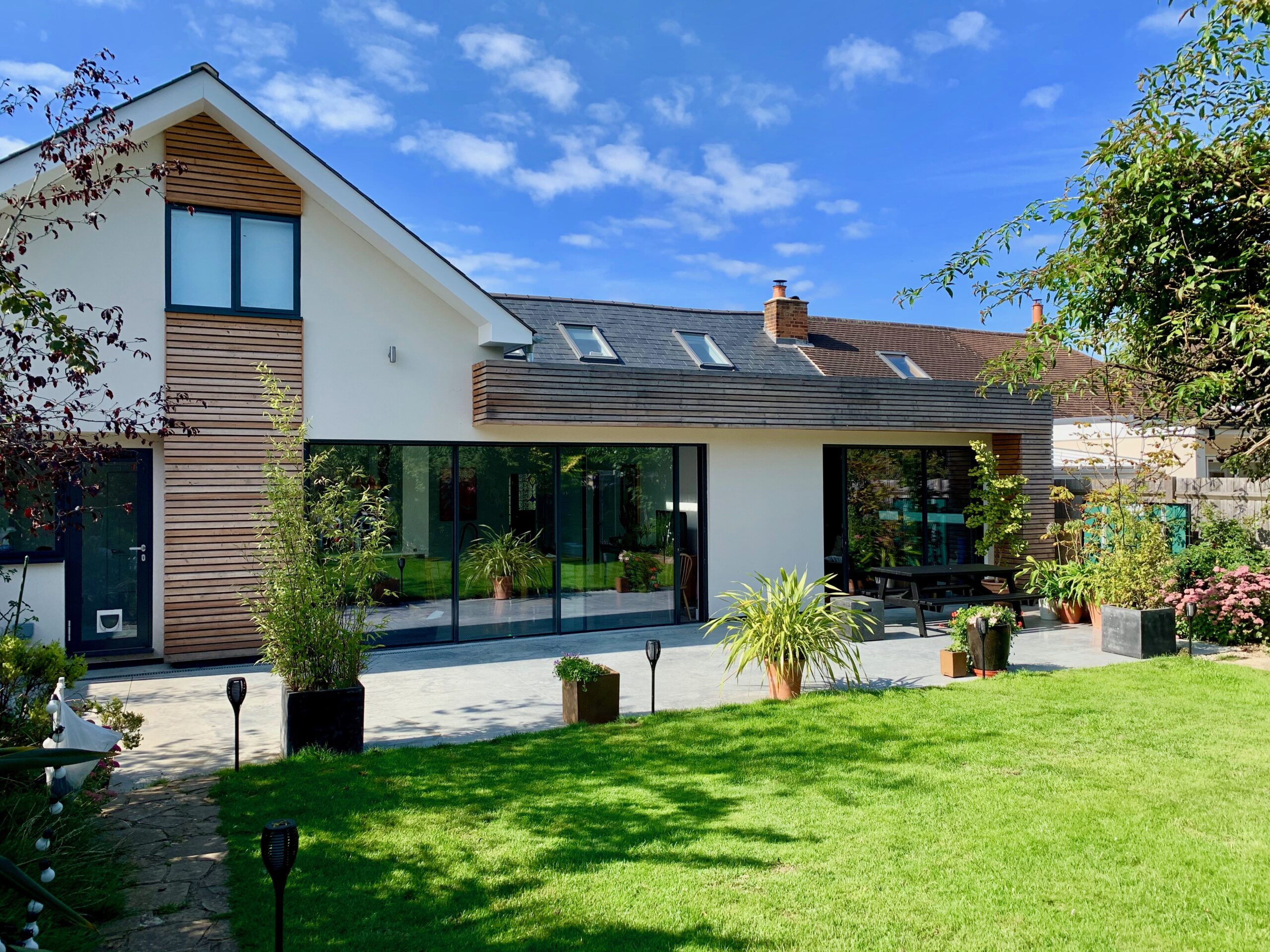 Surrey bungalow conversion and double-storey extension by OSPIN, transforming an existing home with modern architecture, open-plan living and a contemporary white timber-clad exterior.