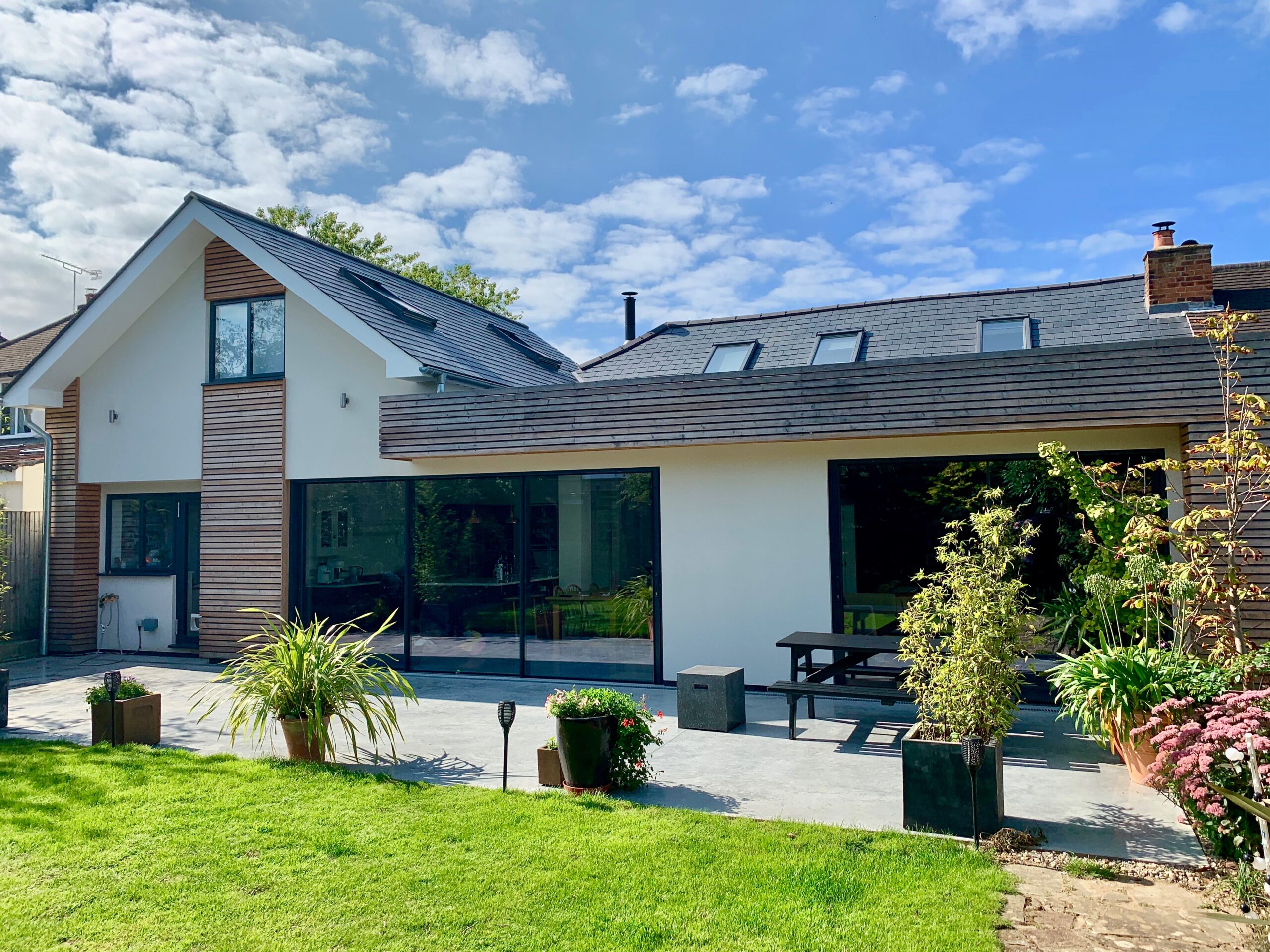 Surrey bungalow conversion and double-storey extension by OSPIN, transforming an existing home with modern architecture, open-plan living and a contemporary white timber-clad exterior.