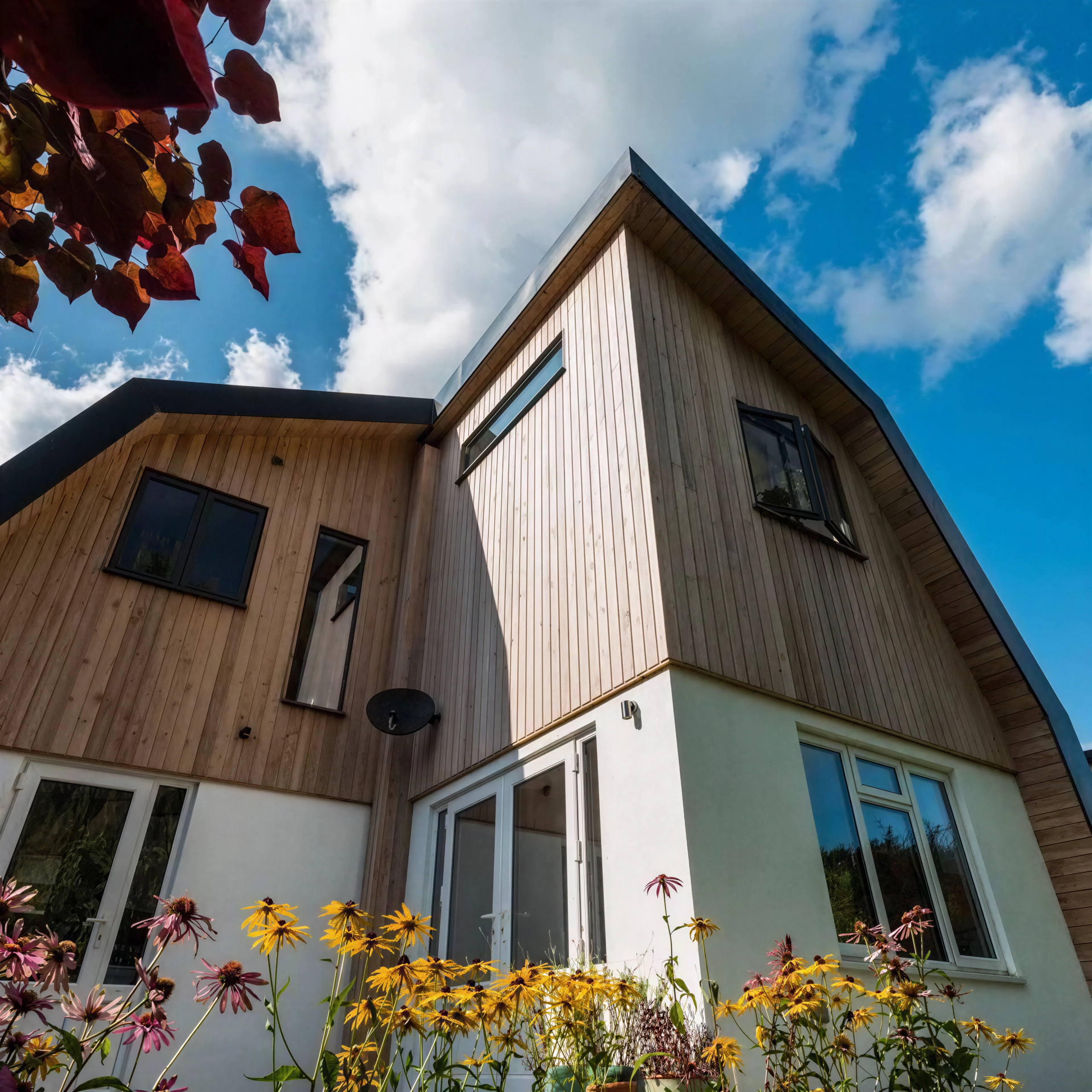 Dutch barn-style home conversion featuring vertical larch cladding, aluminium standing seam detailing and contemporary architecture designed by OSPIN.