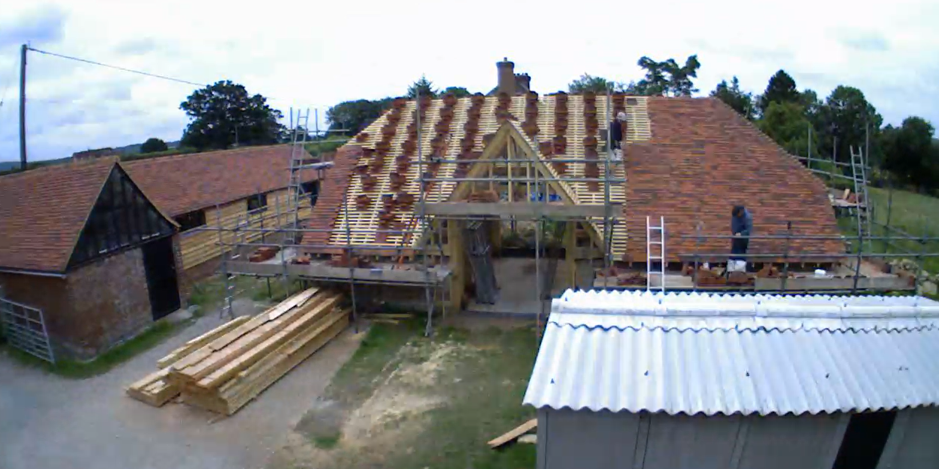 Photo showing the restoration of a traditional Kent farmstead, including the reconstruction of a historic milking shed and threshing barn using reclaimed materials.